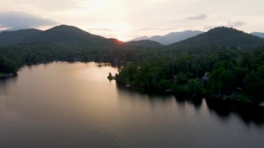 Placid Gölü 'nün Sunrise' da yüzücüyle çekilmiş 4K Hava Aracı videosu. Gölde gün doğumunun yansıması