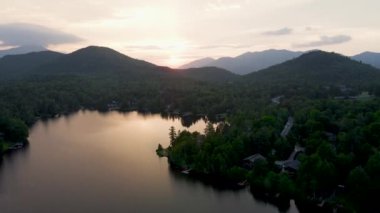 4K Hava Aracı, Gün Doğumu 'nun Gündoğumu videosu Placid Gölü ve Dağları' nın üzerinde. Gölde gün doğumunun yansıması