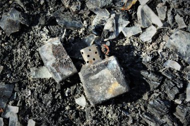 Kül içinde yanmış metal çakmak. Eski Zipo çakmağını aç.