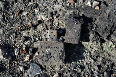 Kül içinde yanmış metal çakmak. Yangının sonuçları. Yakın plan.. 