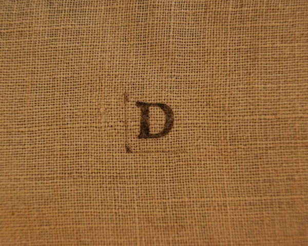 Letter D. Stamp letters on linen fabric