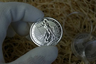 Numismatist 'in elinde kapsüldeki gümüş para. Birleşik Krallık gümüş sikkesi 1 kilo Britanya 2023. Saf gümüş yatırım parası.. 