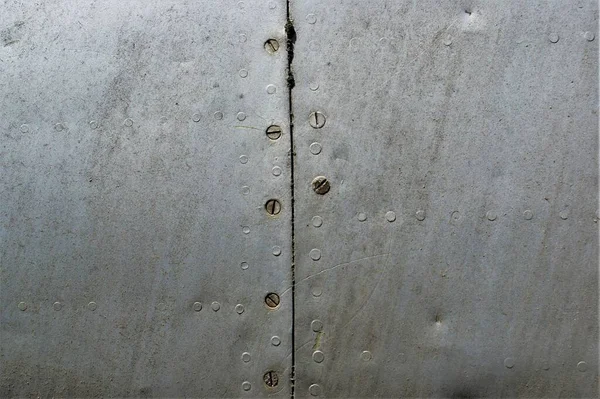 a fragment of a very old aircraft fuselage. Vintage metallic background.