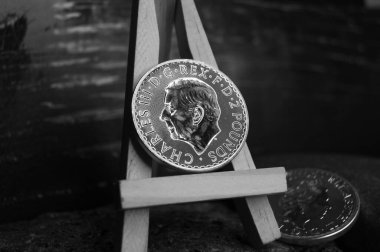 İngiltere sehpasında saf gümüş para. 1 Pound Charles III. Siyah beyaz fotoğraf.