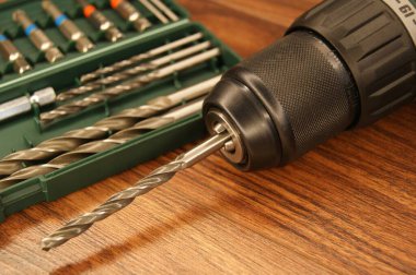 Yeni matkap seti. Koyu ahşap bir masada matkap ve matkap seti. Yakın plan.