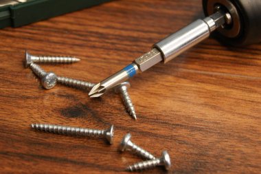 Tornavida ısırığı ve metal vidalar koyu masa üstünde, yakın çekim