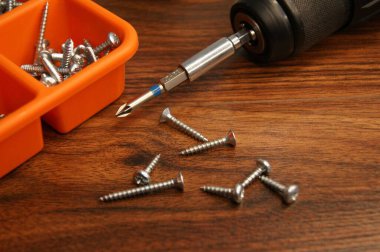 Vidalar, vida tabancası ve kırmızı tornavida..