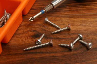 Vidalar, vida tabancası ve tahta bir masaya vida kutusu, yakın plan..