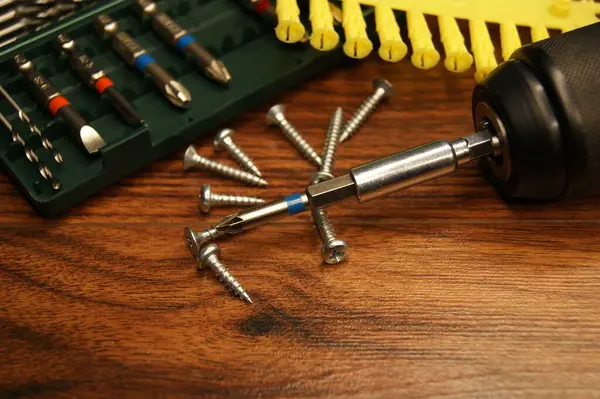 Çeyiz, vida, tornavida, bit takımı. Ahşap bir yüzeyde aletler ve bağlayıcılar