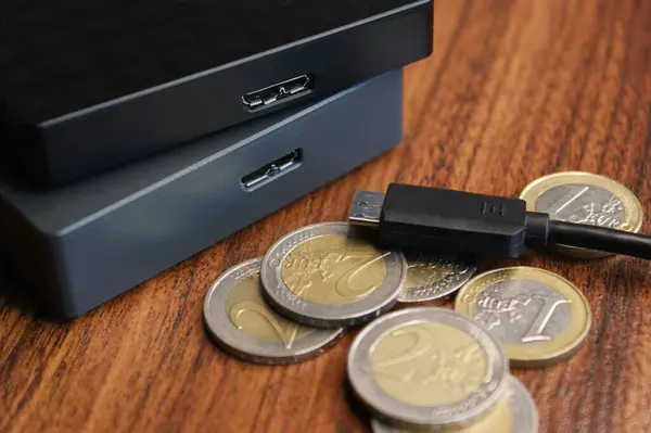 External hard drive with cable close-up. External hard drives and euro coins.