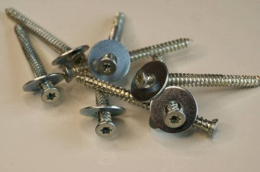 Beton için vidalar. Beyaz arkaplanda yeni vidalar bağlanıyor. 