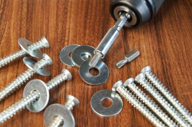 Montajcının çalışma ortamı. Tahta masadaki beton ve metal yıkama vidaları..