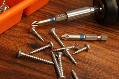 Teçhizatçının iş yerine yakın çekim. Tahta bir masada vida ve tornavida.. 