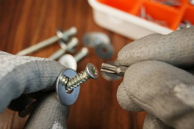 Vidalar ve tornavidalar inşaatçıların eline geçti. İnşaatçının çalışma sürecini kapat.