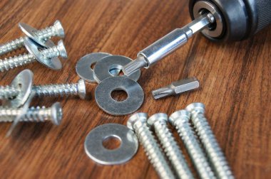 Montajcının çalışma ortamı. Tahta masadaki beton ve metal yıkama vidaları..