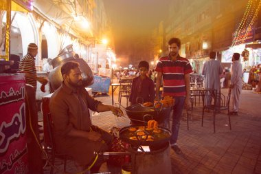 Sokak satıcısı Lahore Pakistan 'da Jalebi yemeği hazırlıyor.