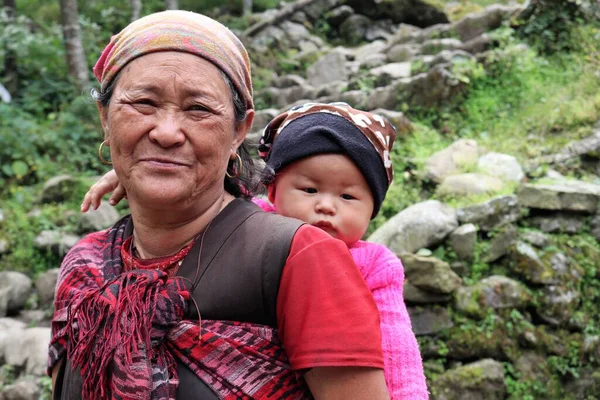 Surke Village, Nepal, 3 Ekim 2018 - Geleneksel bir Sherpa büyükannesi ve torunu Lukla, Nepal yakınlarındaki dağ köylerinde görevlerini yapıyorlar.