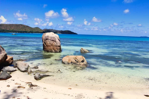 塔卡马卡海滩附近的一个岩石海岸线凸显出普拉斯林岛附近的蓝色水域 — 图库照片