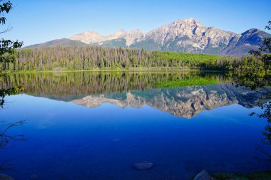Piramit Dağı sabahın erken saatlerinde Kanada kayalıklarında Jasper yakınlarındaki Patricia Gölü 'nün sersemletici suları gibi camdan yansıdı.