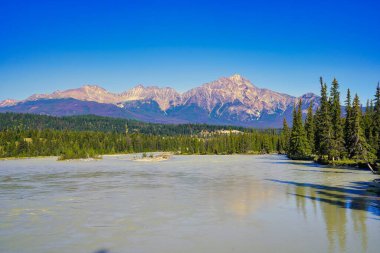 Piramit dağı, Kanada kayalıklarında Jasper yakınlarındaki Athabasca nehrinin panoramik manzarasının üzerine çöker.