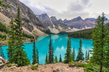 Moraine Gölü 'nün turkuaz mavi suları Kanada' daki Banff Ulusal Parkı 'nın zirveleriyle çevrilidir.