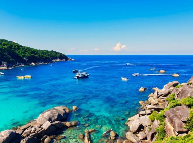 Tayland, Phuket açıklarında Andaman Denizi, Similan Adaları 'ndaki kayalıkların tepesinden ışıltılı gök mavisi sularıyla manzaralı deniz manzarası.