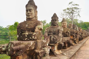 Angkor Thom - Okyanus Hindu mitolojisinin çalkantılı sahnesinde Siem Reap, Kamboçya, Asya 'daki Bayon tapınağına giden yolda sıra sıra dizilmiş tanrılar ve iblisler görülüyor.
