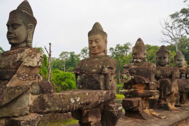 Angkor Thom - Okyanus Hindu mitolojisinin çalkantılı sahnesinde Siem Reap, Kamboçya, Asya 'daki Bayon tapınağına giden yolda sıra sıra dizilmiş tanrılar ve iblisler görülüyor.