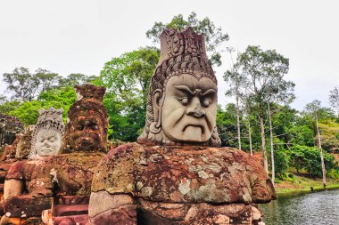 Angkor Thom - Okyanus Hindu mitolojisinin çalkantılı sahnesinde Siem Reap, Kamboçya, Asya 'daki Bayon tapınağına giden yolda sıra sıra dizilmiş tanrılar ve iblisler görülüyor.