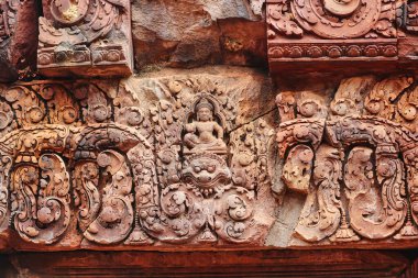 Lintel, Siem Reap, Kamboçya, Asya 'daki Banteay Srei tapınağındaki Hindu mitolojisinden tanrıların kabartmasıyla oyma yapıyor.