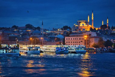 İstanbul, Türkiye 'de yoğun Eminonu rıhtımı, Galata köprüsü ve İstanbul' da boğazlı tekneli Süleyman Camii 'nin muhteşem şehir ışıkları ve gece manzarası