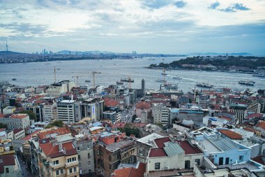 İstanbul şehrinin muhteşem manzarası arka planda modern binalar ve İstanbul, Türkiye 'deki altın boynuz boğazlarına tepeden bakan önplanda sedirli İstanbul sehpası.