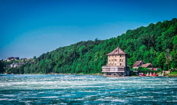 Rheinfall 'daki Castle Worth ya da Schlosschen Worth, İsviçre' nin Schaffhausen yakınlarındaki Rhein nehrindeki manzaralı şelale.