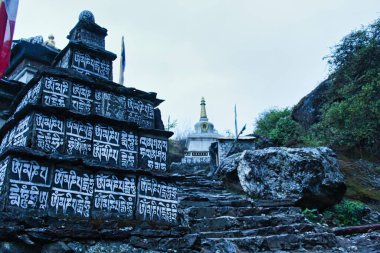 Buddhist Mantra - Om Mani Padme Hum is painted on the rocks along the trekking route to the Everest Base camp from Lukla to Namche Bazaar,Nepal clipart