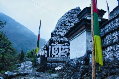 Buddhist Mantra - Om Mani Padme Hum is painted on the rocks along the trekking route to the Everest Base camp from Lukla to Namche Bazaar,Nepal clipart