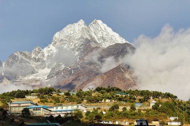 Thamserku twin peaks at 6608 meters shine bright in the morning sun, presenting a magnificent view as it towers above the sherpa market town of Namche Bazaar in the high Himalayas of Khumbu, Nepal clipart
