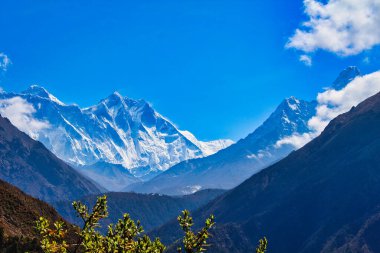 Magnificent view of the Everest Massif and Ama Dablam set against a blue sky behind deep valleys during the Everest Base camp trek near Namche Bazaar, Nepal clipart