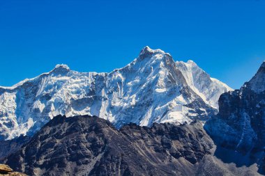 7916 metredeki Ngozumpa Kang Cho Oyu ile aynı tepenin üzerindedir ve Nepal 'de Gokyo Ri' den görülen Nepal ve Tibet arasındaki sınırı oluşturur.
