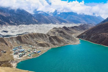 Gokyo Tsho or Dudh Pokhari is an emerald green high altitude Himalayan lake at 4700 meters,listed as a Ramsar wetland on the shores of Gokyo bordering the vast Ngozumpa glacier in Nepal clipart