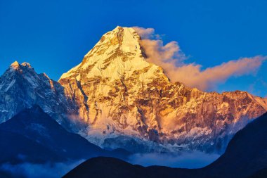 Resplendent Ama Dablam is bathed in the golden light of a scenic Himalayan sunset as seen from the scenic village of Pangboche in the upper Khumbu, Nepal clipart