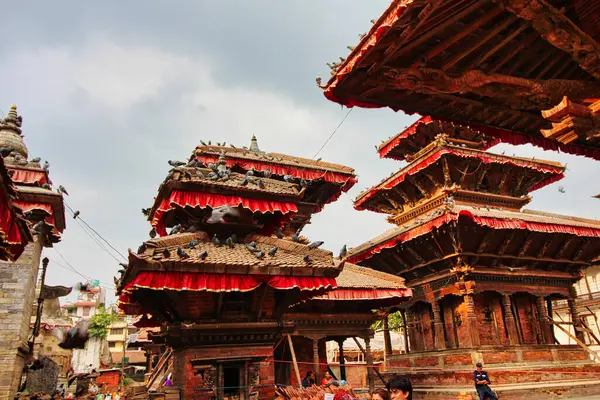 在尼泊尔加德满都 鸽子在繁华的杜巴尔广场上飞奔 该广场是一个具有历史意义的城市中心 有着历史意义的木制树冠 寺庙和神龛 — 图库照片