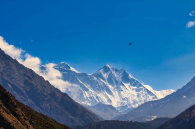 Bir helikopter Everest ana kampına gider ve parlak bir yaz gününde Namche Çarşısı 'ndan yükselen Everest ve Lhotse duvarlarına karşı görülebilir.