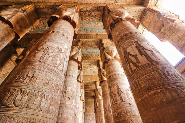 Magnificent hypostyle columns topped by faces of Hathor and vibrant ceiling art in the Temple of Hathor at Dendera completed in the Ptolemaic era around 50 BC between Luxor and Abydos towns,Egypt