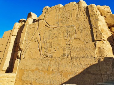 Famous wall bas relief showing the Great Pharoah Thutmosis III slaying Canaanite prisoners at the Battle of Megiddo at the 7th Pylon of the Karnak temple complex dedicated to Amun-Re in Luxor,Egypt clipart