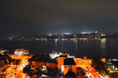 Quebec 'teki Feribot terminalinin gece ışıkları ve Kanada' nın Quebec kentindeki Dufferin Terası 'ndan görüldüğü gibi St. Lawrence nehrinin karşı kıyısındaki Levis kıyı şeridi.