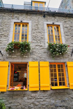 Kanada 'nın Quebec eyaletinin başkenti Quebec' te yer alan kraliyet bölgesindeki geleneksel taş konut ve sanat galerilerinin parlak sarı çerçeveli pencereleri
