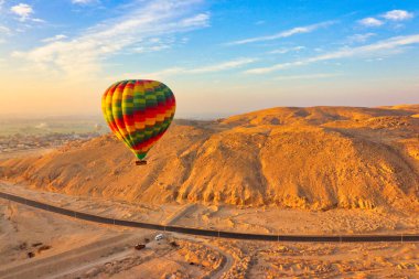 Sıcak hava balonları turistleri Sahara Çölü ve Luxor kasabasından geçirir. Mısır 'ın Luxor yakınlarındaki geniş bir mezarlık manzarası vardır.