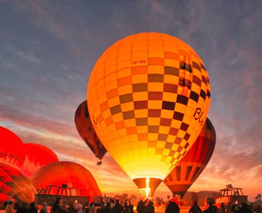 Sıcak hava balonları Luxor balonu operatörleri tarafından turistler için hazırlanıyor. Mısır 'ın Luxor kenti yakınlarındaki şafak öncesi karanlıkta geniş Theban mezarlığında gezinti için.