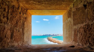 M.S. 1479 'da, Pharos Adası, İskenderiye, Mısır' da, MÖ 1479 'da Mamluk Sultan Kaitbay tarafından inşa edilen Qaitbay Kalesi' ndeki mavi Akdeniz 'e uzanan devasa taş duvarları gören bir pencere.