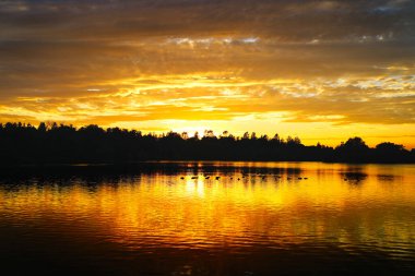 Ottawa, Ontario, Kanada 'da sıcak bir sonbahar günbatımında Ottawa' daki güzel ve sakin Dows Gölü 'nü kaplar.
